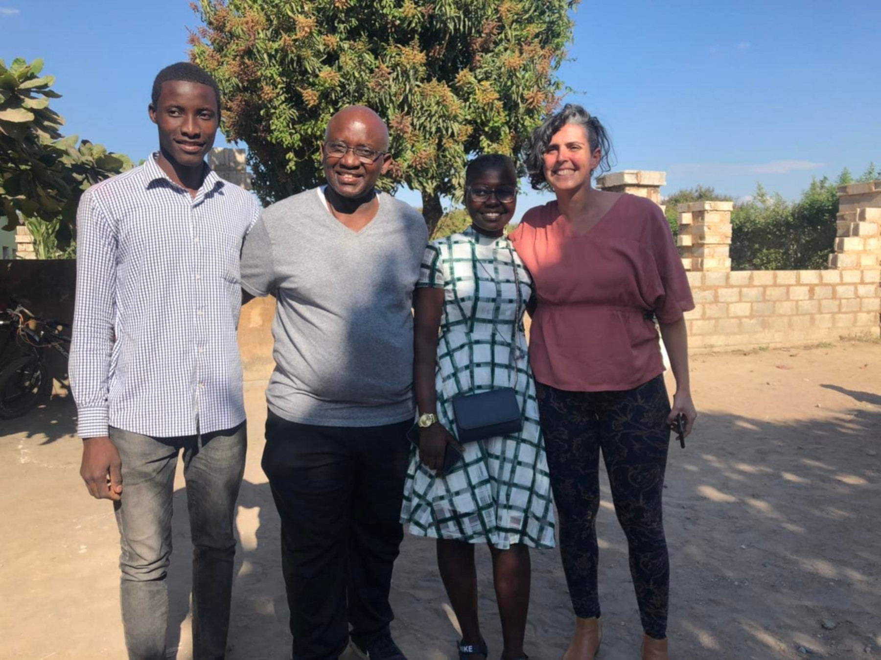 Maureen Mbanga and Ngambela Zulu with Dr. Moono and Julie-Anne Savarit-Cosenza, Co-Founder and Executive Director of the African Education Program, outside in Zambia