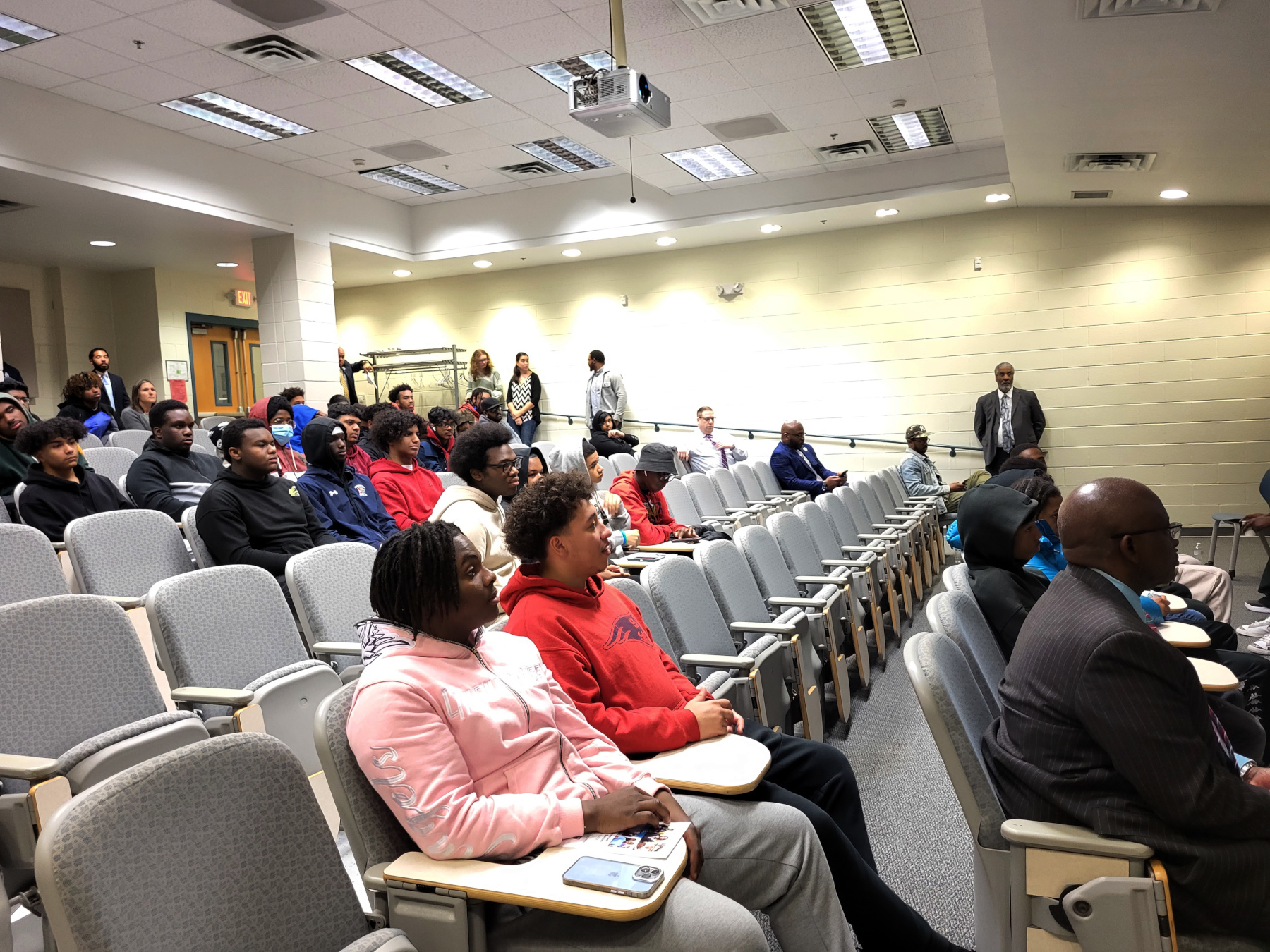 Student seated in Stockade Building lecture hall, listening to panel discussion