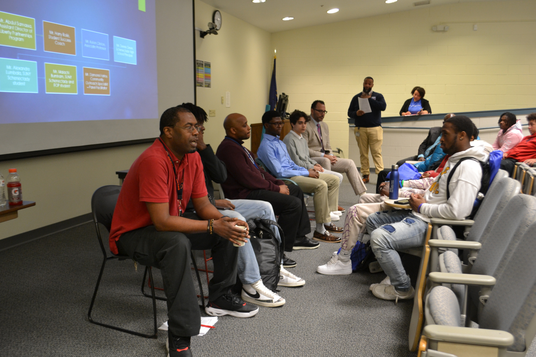 Panelists seated at front of the room, speaking to students in Stockade Building lecture hall