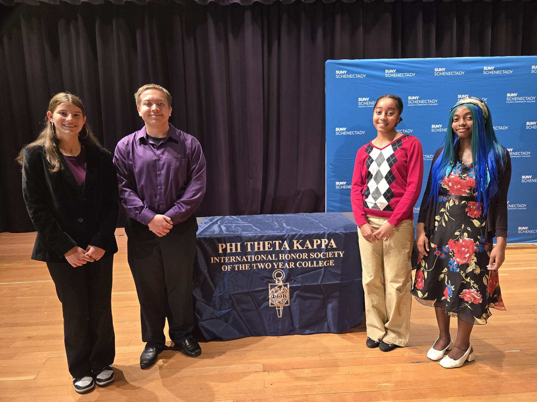 Four students standing on stage