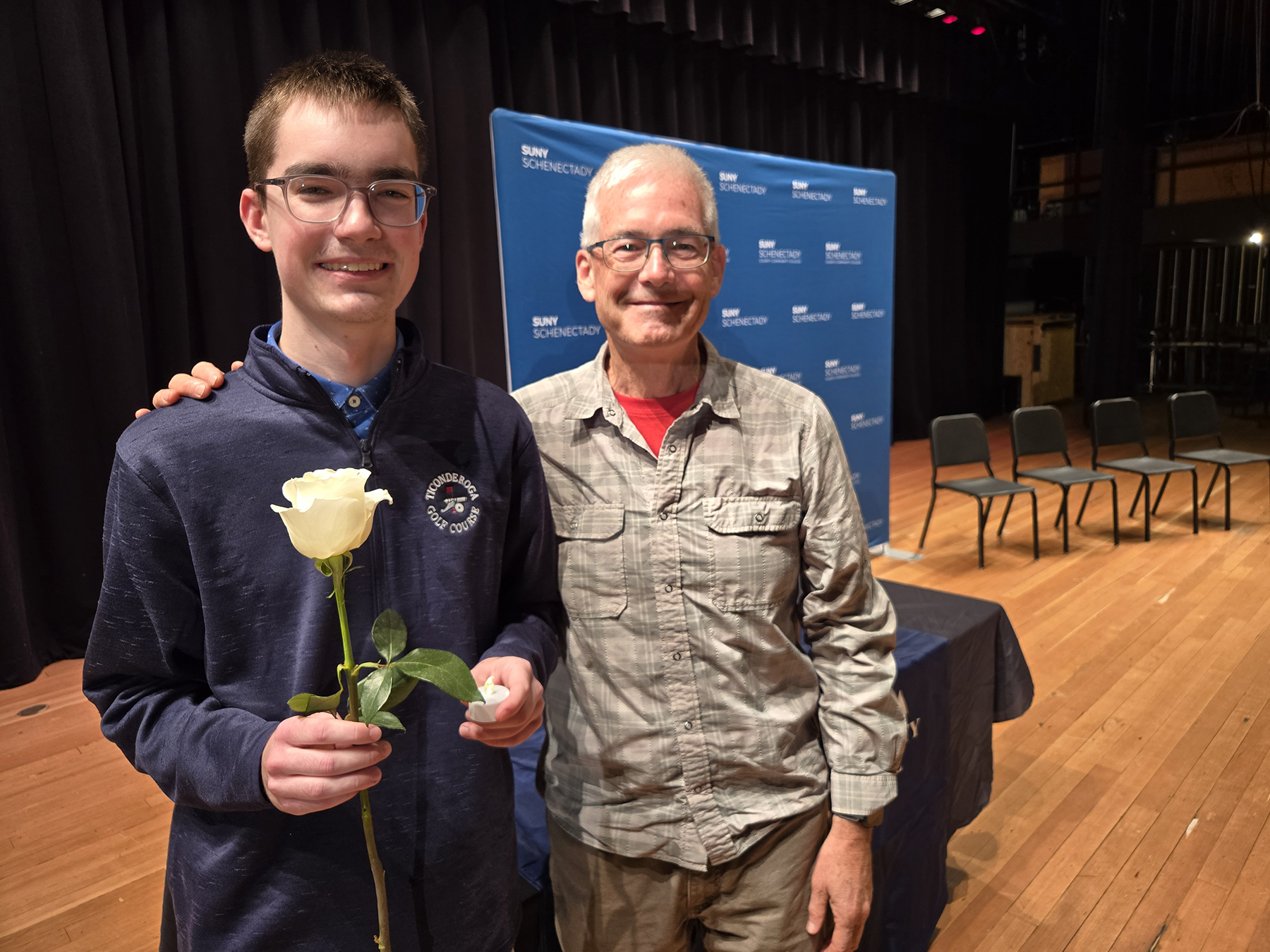 Student and family member standing on stage