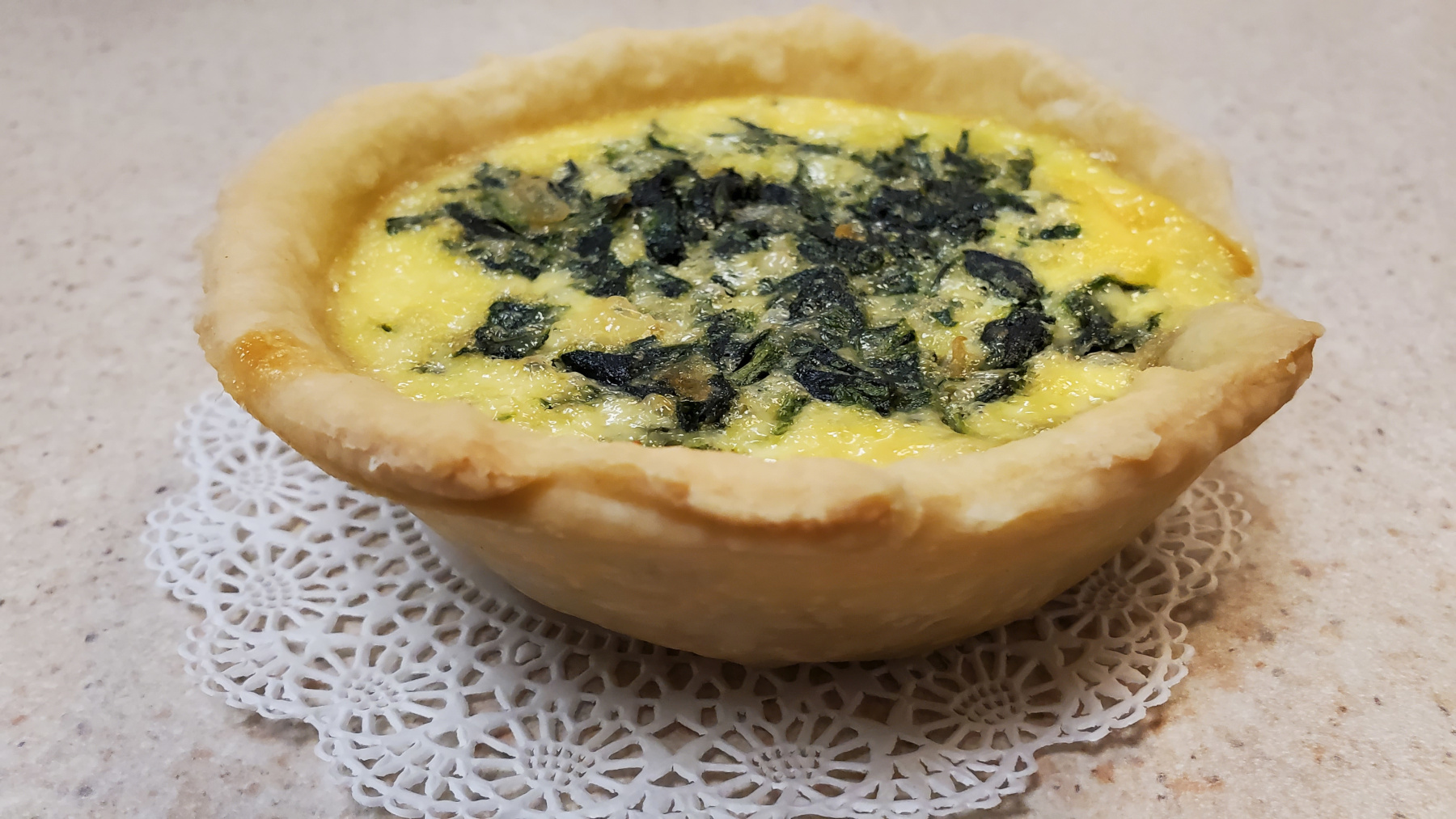 Spinach and cheese quiche on counter