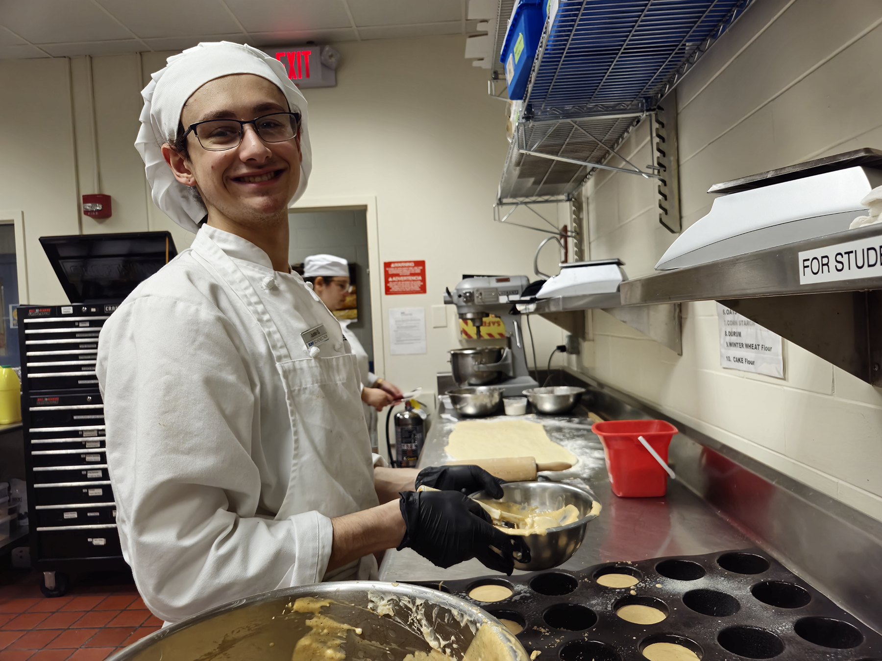 Student smiling, in chef's uniform