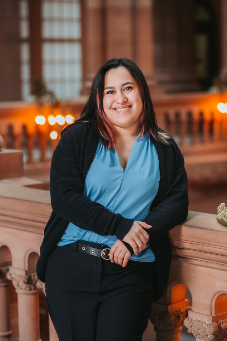 Rayanne Vasquez, smiling, standing up in New York State Senate office