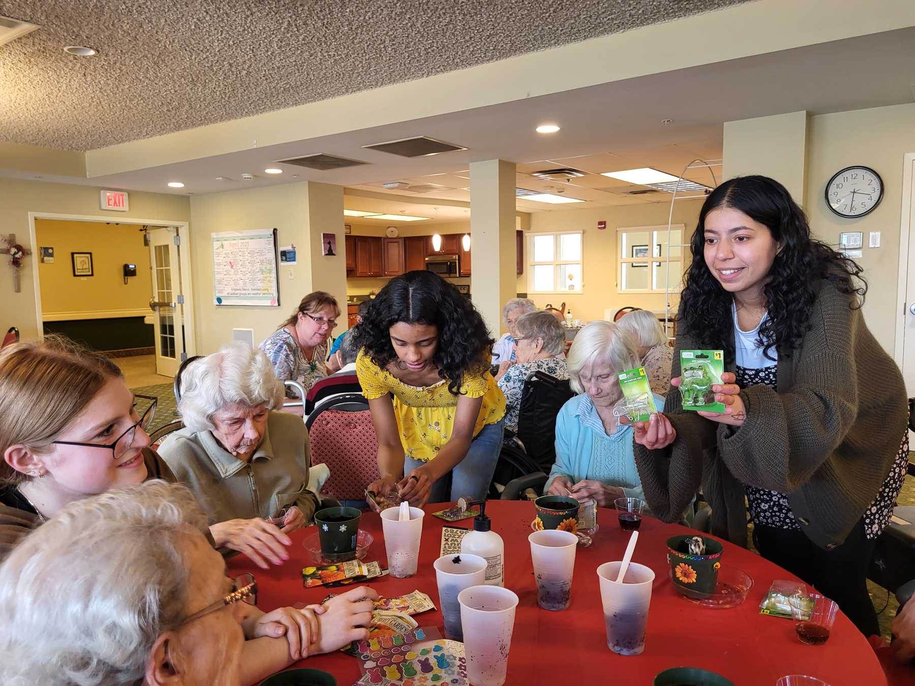 Students planting seeds in flowers pots with residents