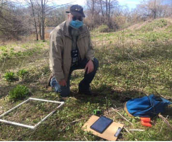 Dr. Richard Simons wearing medical mask outside with science equipment