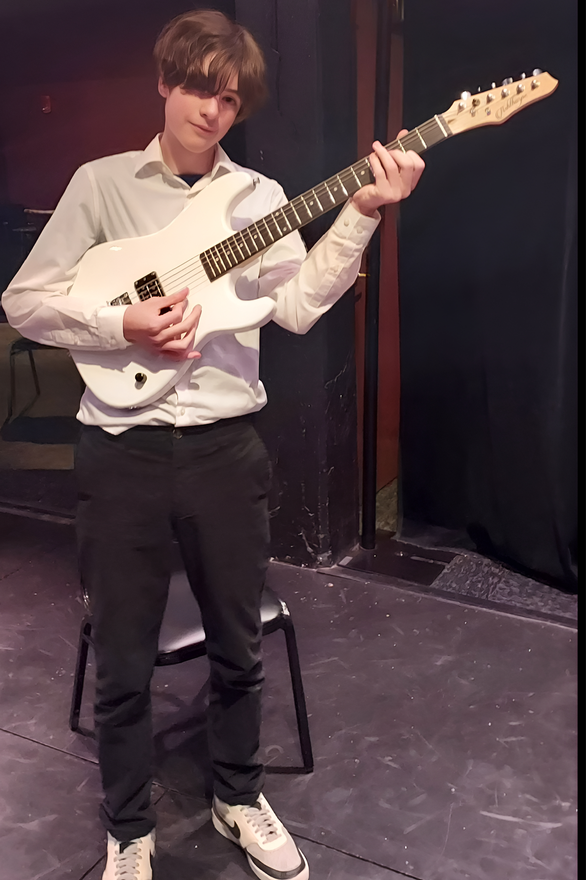 River Henriksen standing with guitar
