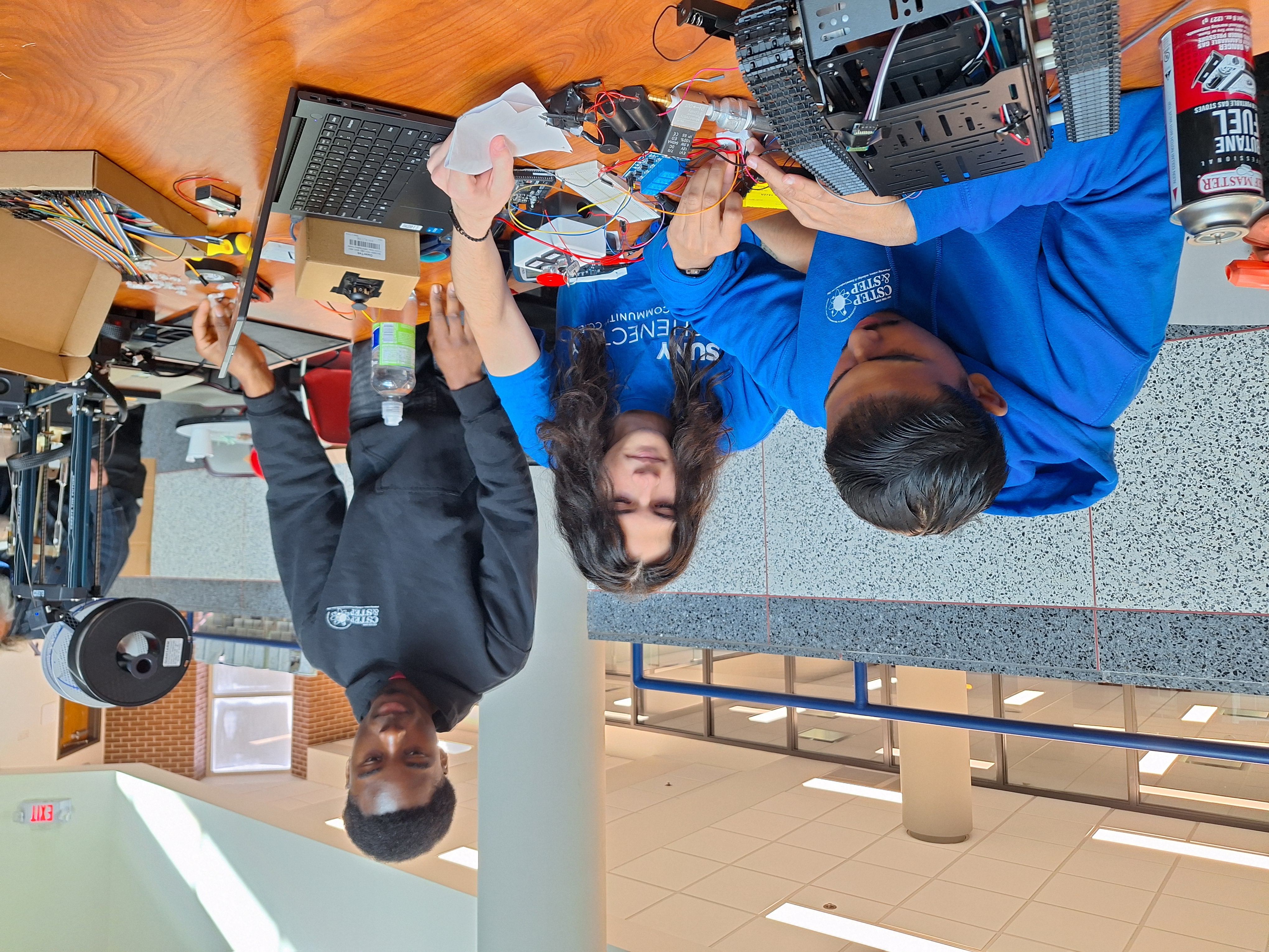 Students working on science experiment, seated at table