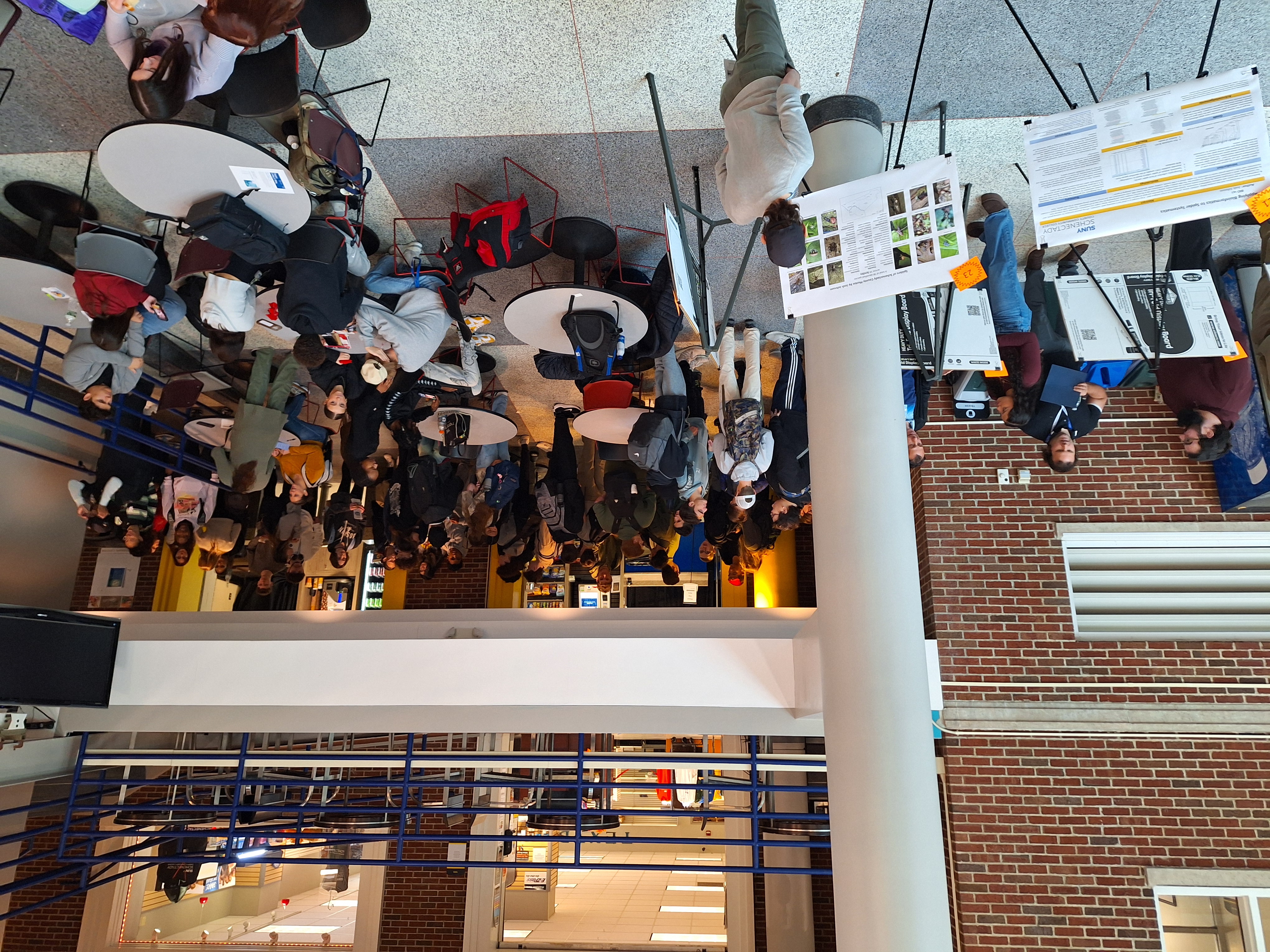 Visting students standing in crowd near research posters