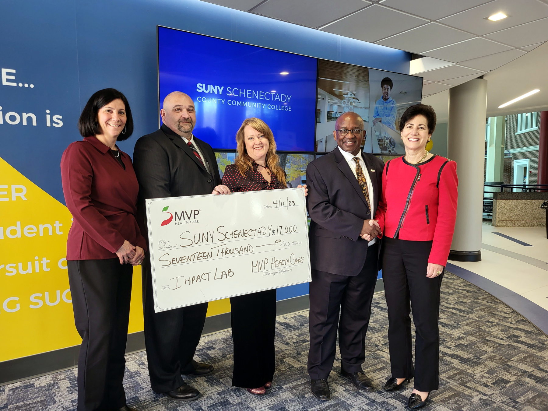 College officials and MVP officials with large check for MVP Healthcare Impact Lab