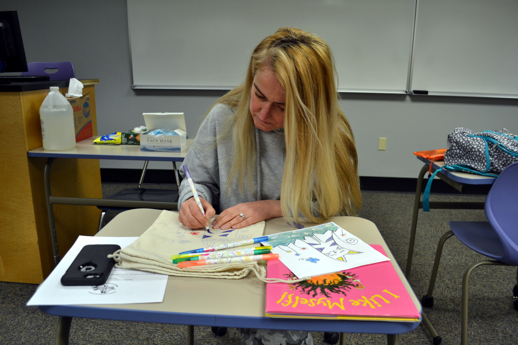 Melahat McQueeney decorating totebag in classroom