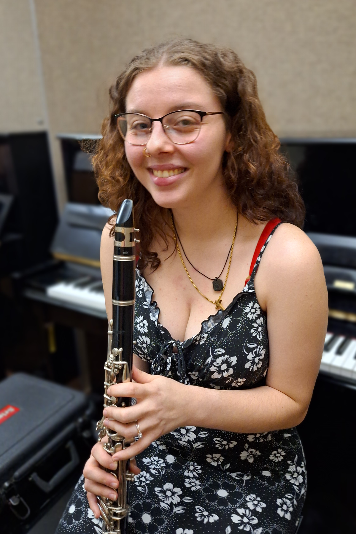 Savannah Wood, holding clarinet in School of Music practice room, smiling