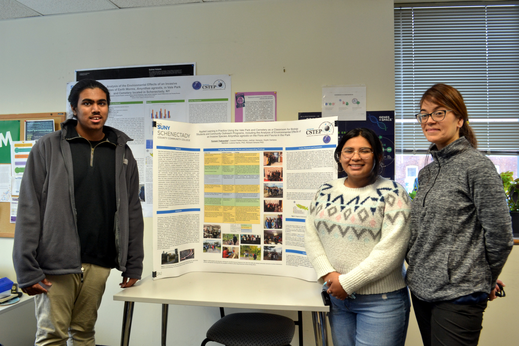Science students Parmesh Thakoordial and Cassiel Achan and Dr. Lorena Harris standing in front of their science poster