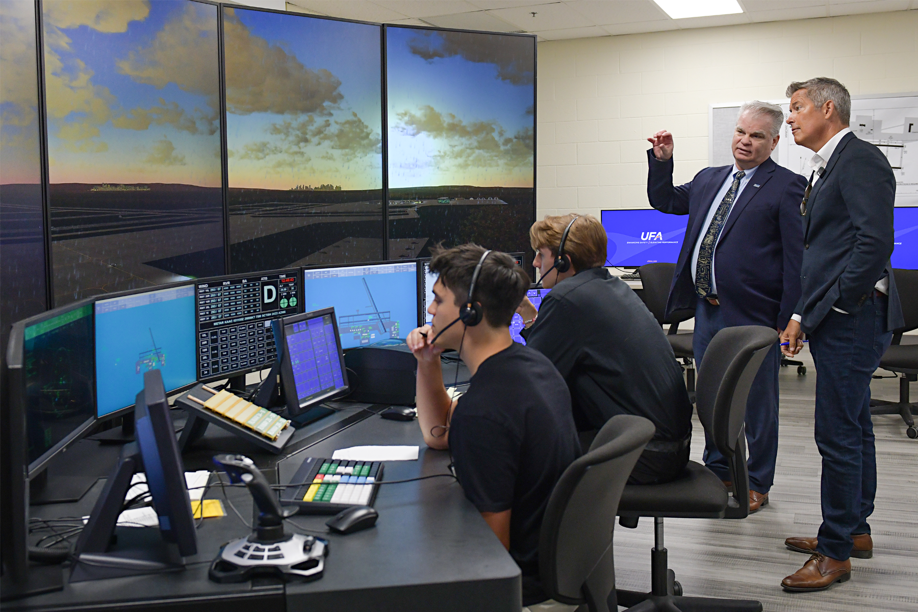 Secretary Duffy, Mike Gersh, and two students near Air Traffic Control Simulator