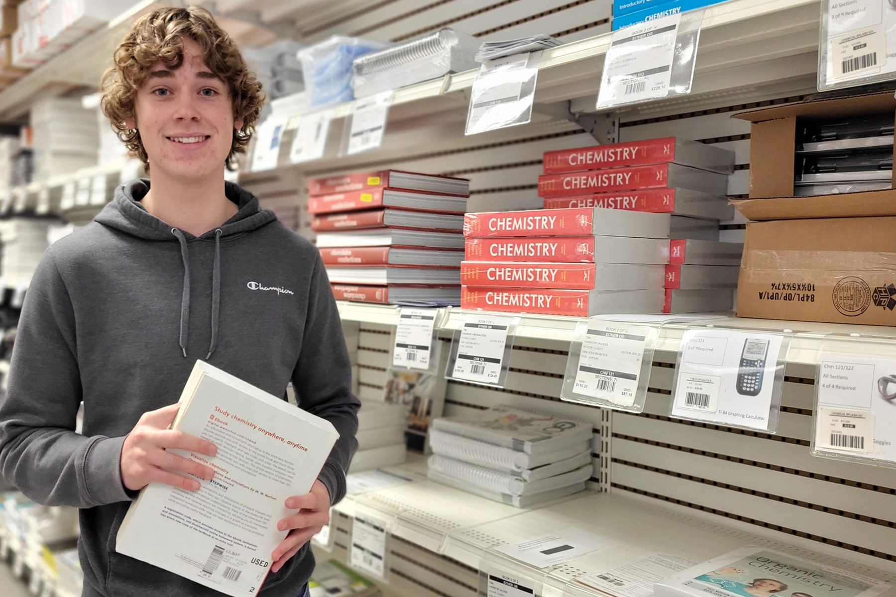 Tanner Litts holding books in the College Store