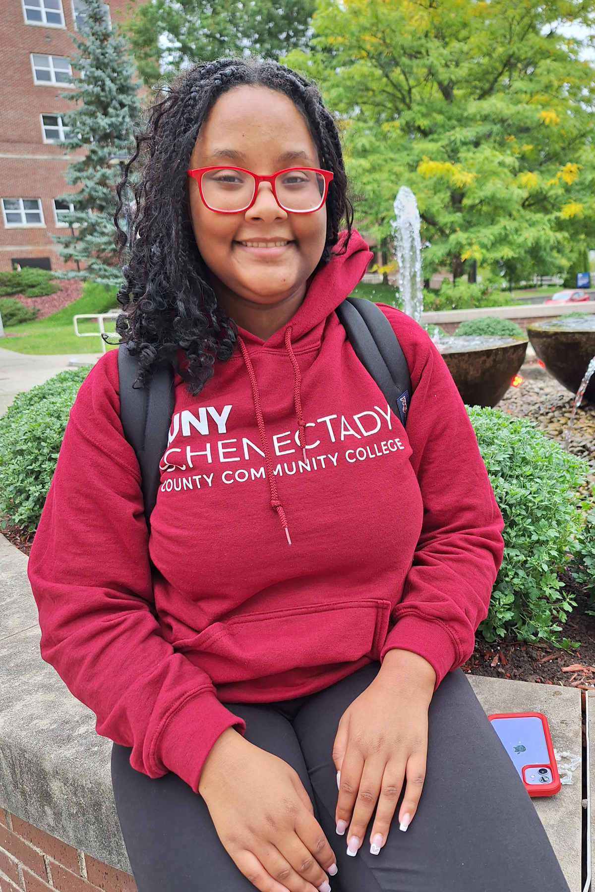 Tia Brown, sitting outside in the quad, smiling