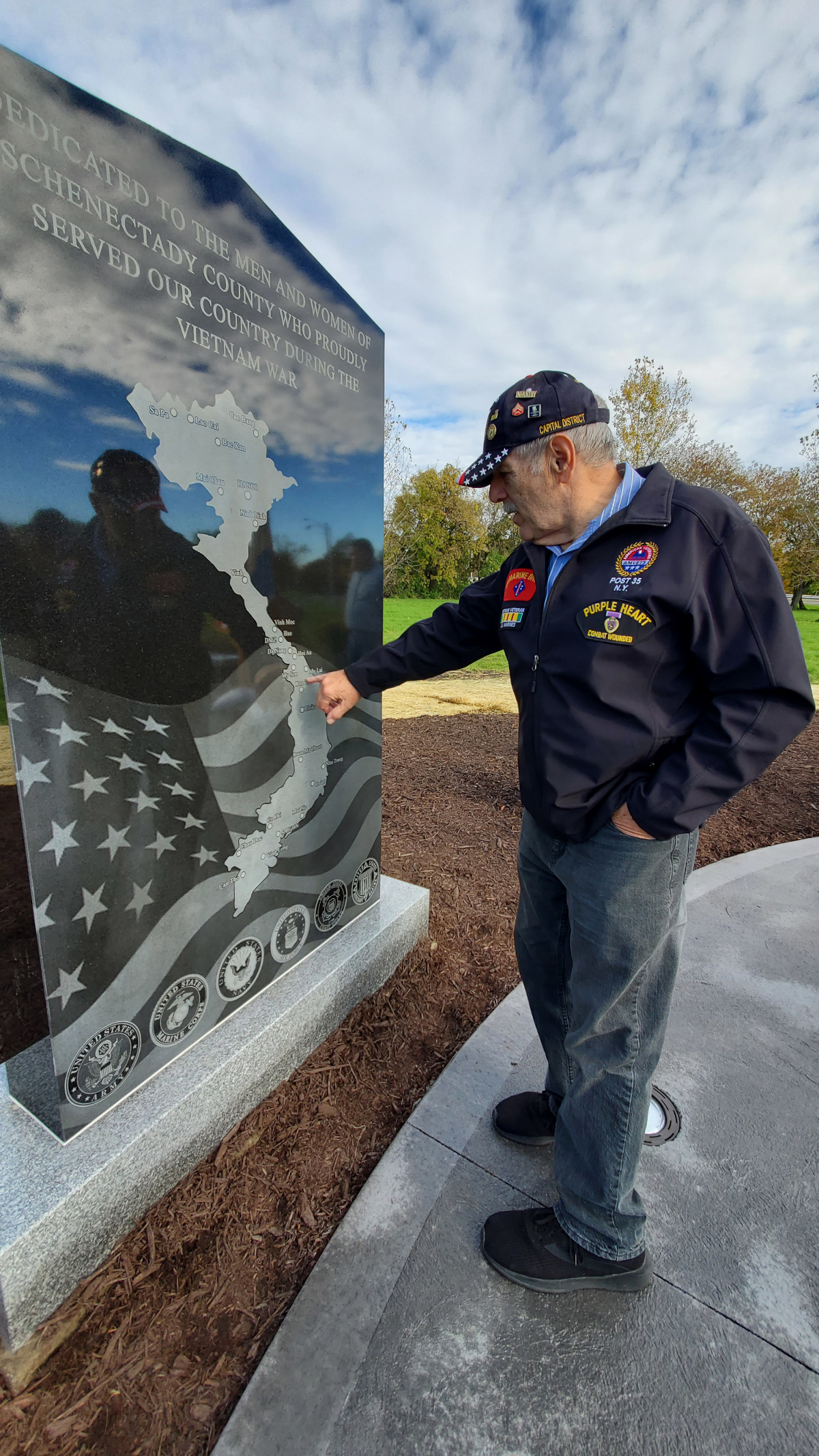 Veteran pointing to area on new Vietnam Veterans Memorial