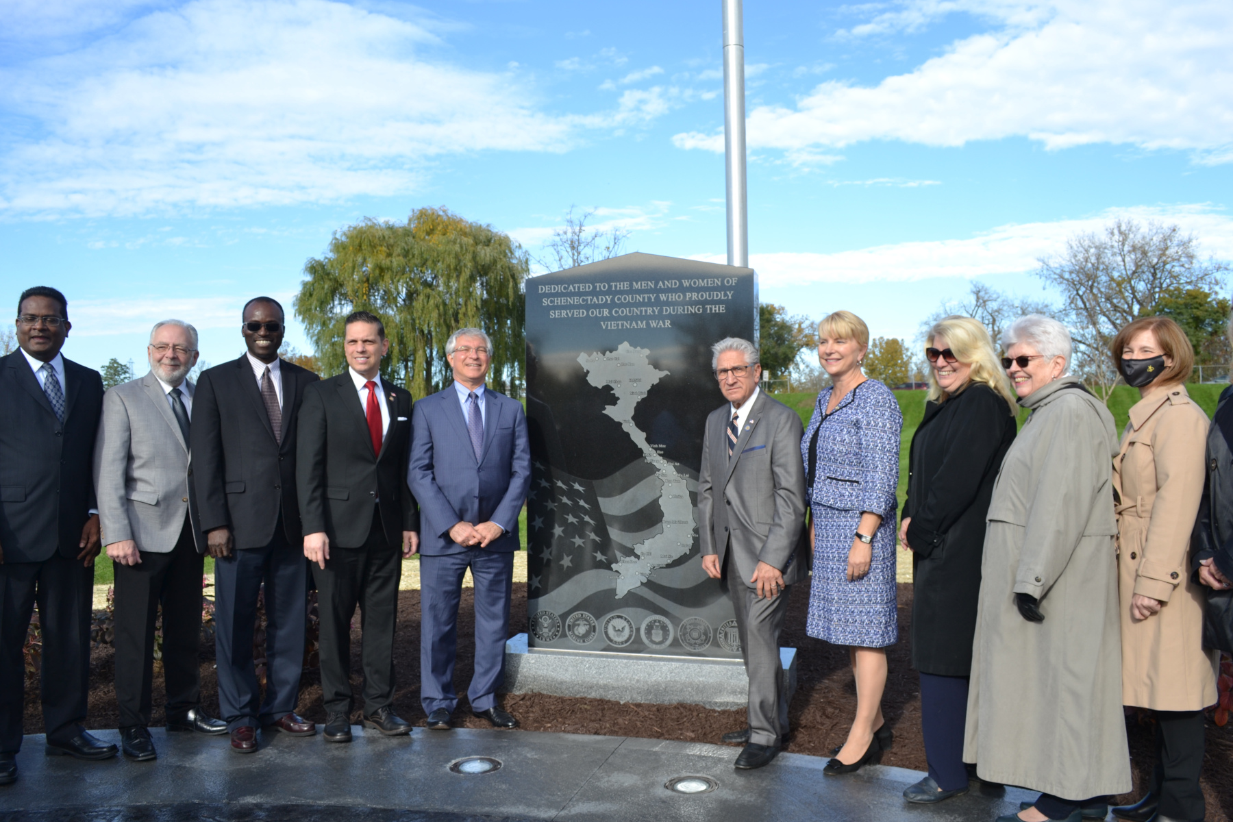 City/county elected officials and other elected officials in front of memorial