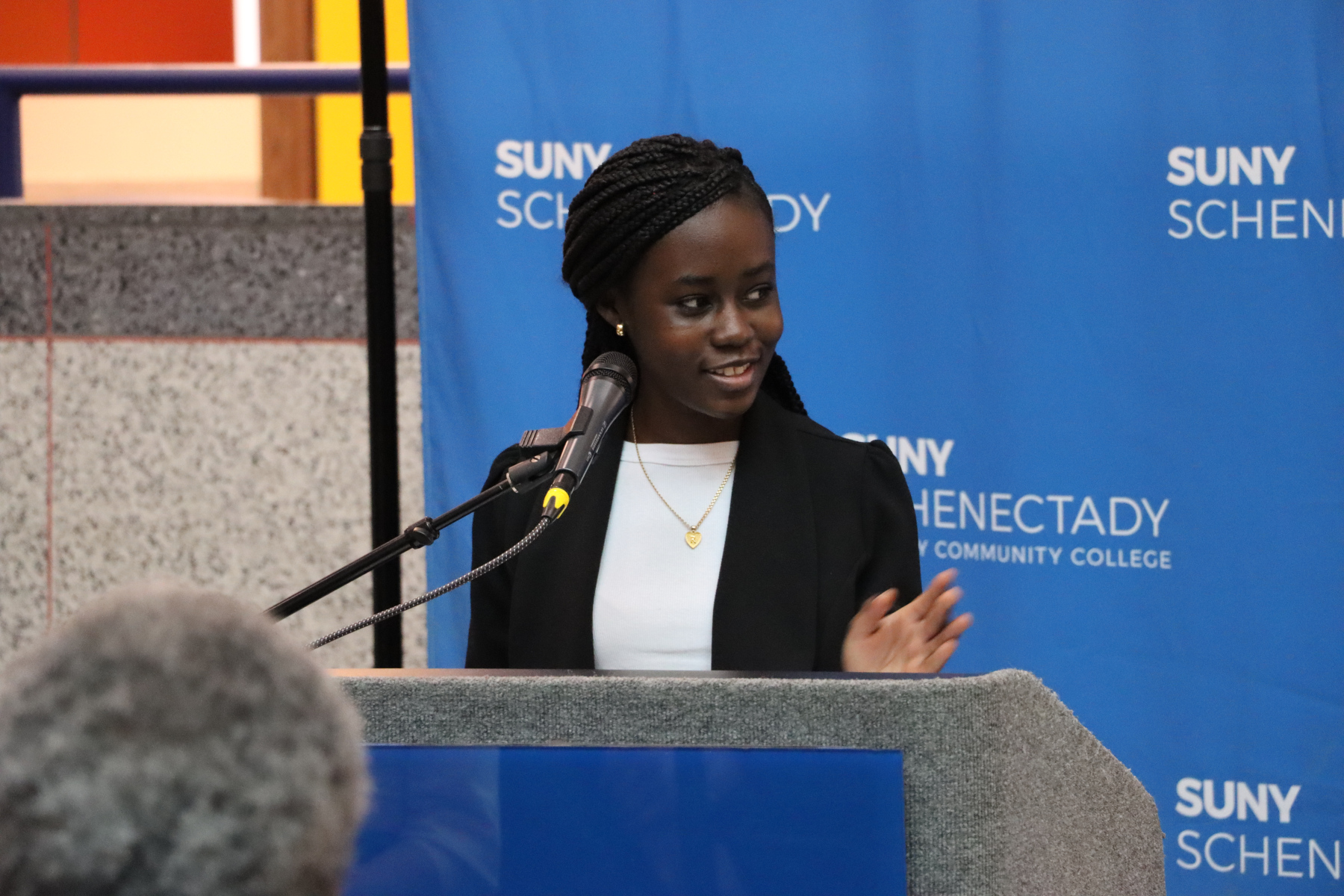 Rondacia McPherson at the podium speaking during the ribbon cutting