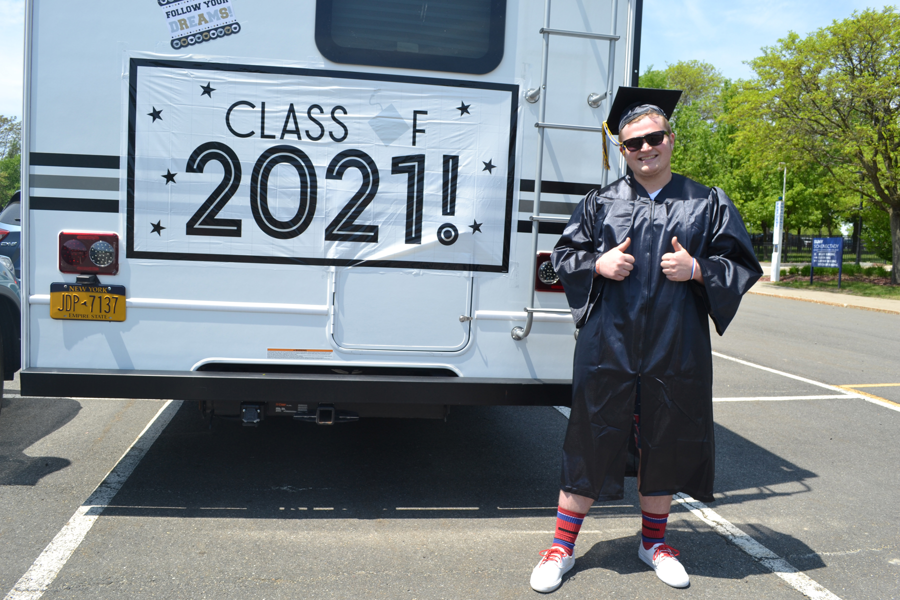 William Gross in cap and gown near RV.