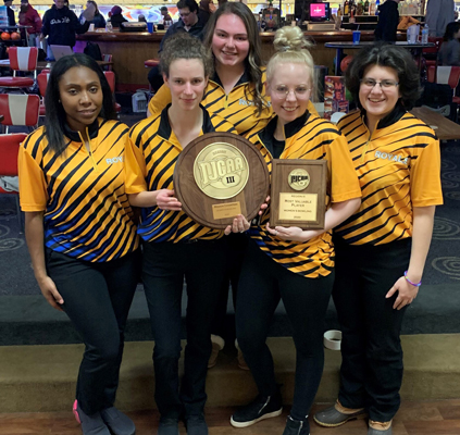 Group photo of female bowlers in uniform on bowling lane