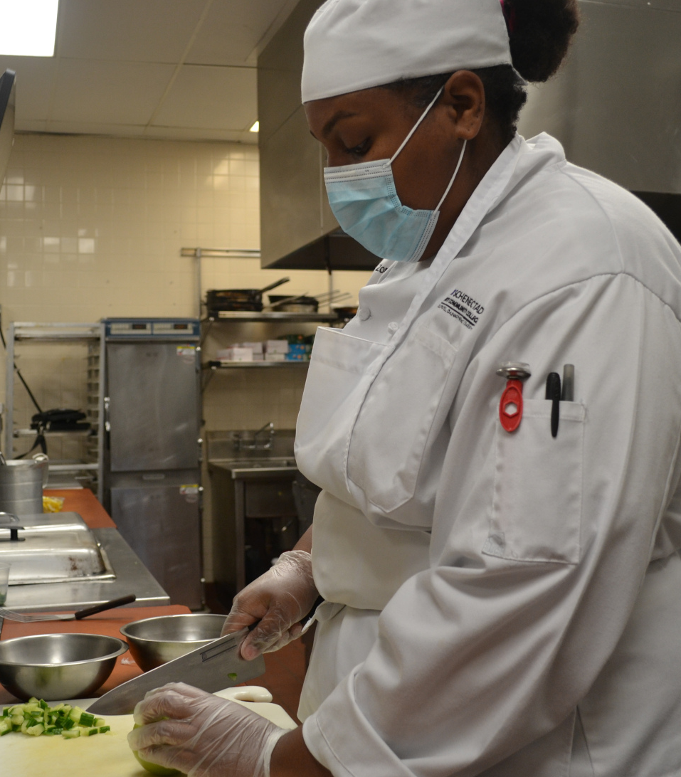Zomy Quiernan in uniform in Culinary Arts lab.