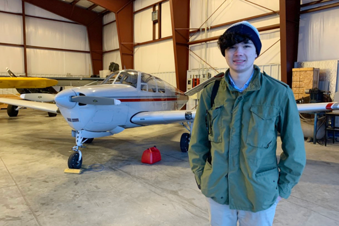 Jonathan Ryan standing in front of airplane inside airport hangar