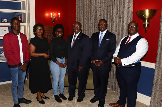 H.E. Amb. Dr. Chola Milambo with College officials and students standing in office