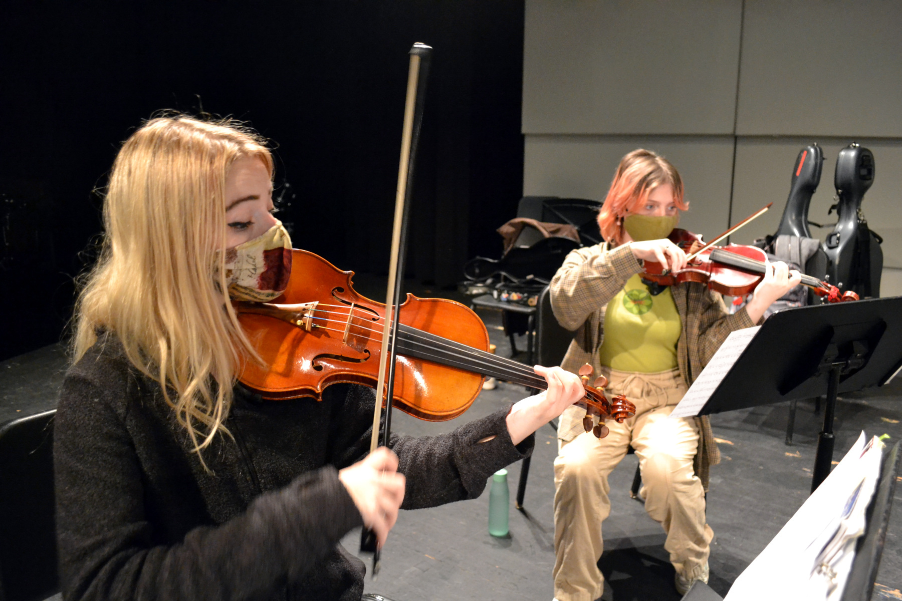 Violinists rehearsing in auditorium