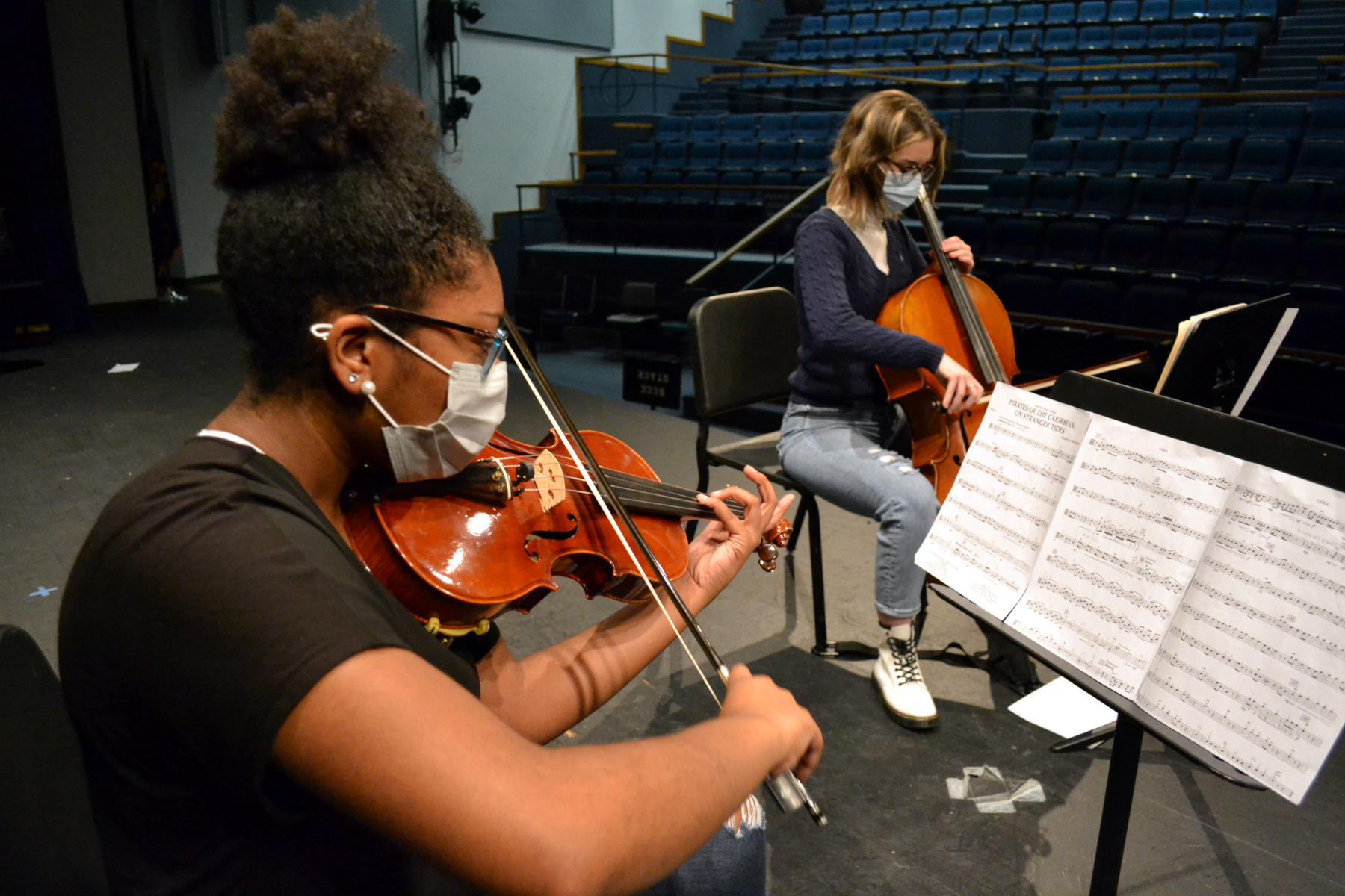 Violinist and cello player rehearsing in auditorium
