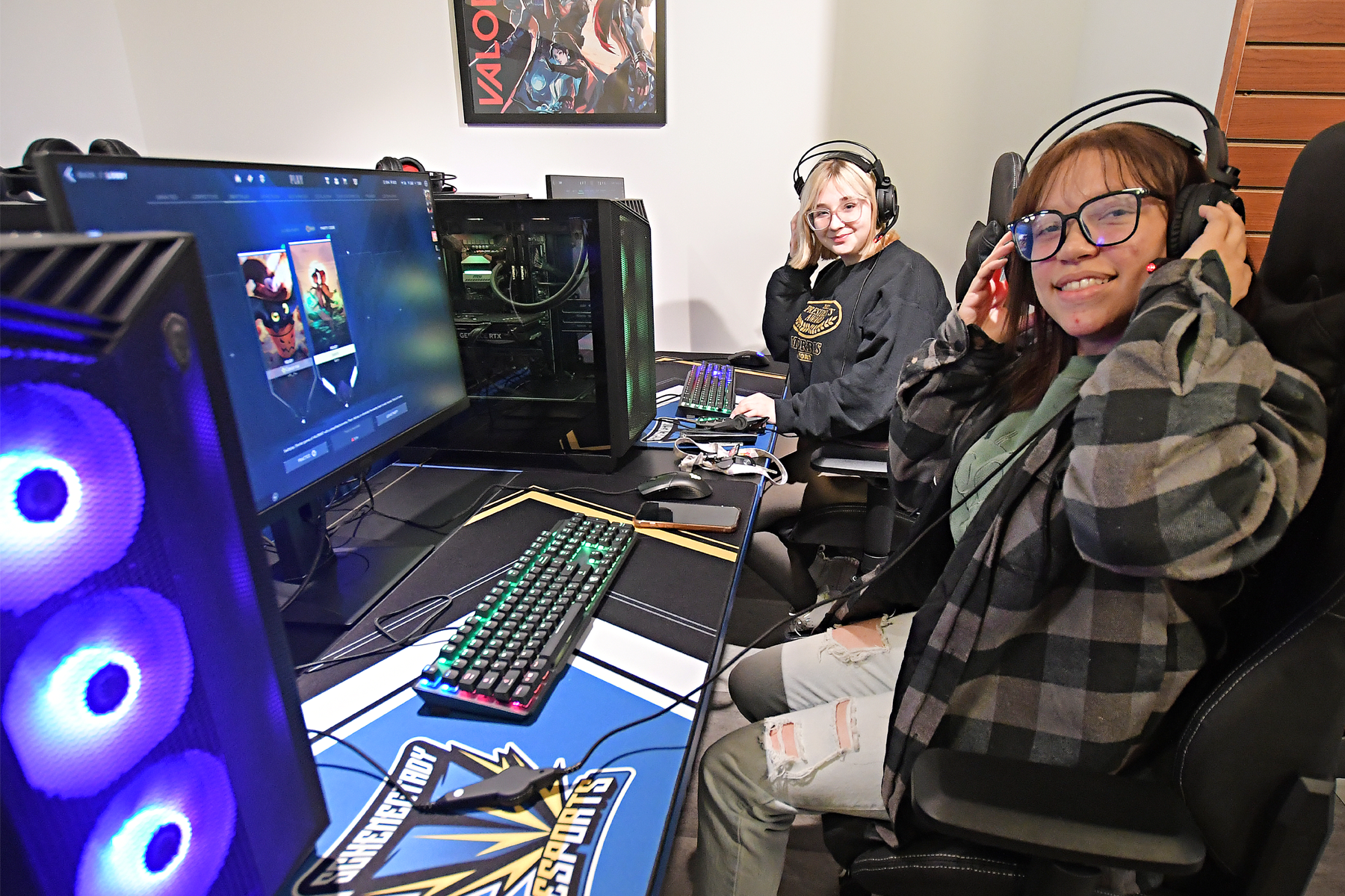 Two students seated at gaming stations, playing games in new eSports Arena