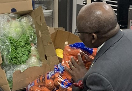 Dr.Moono loading up food donations of lettuce, carrots and lemons.