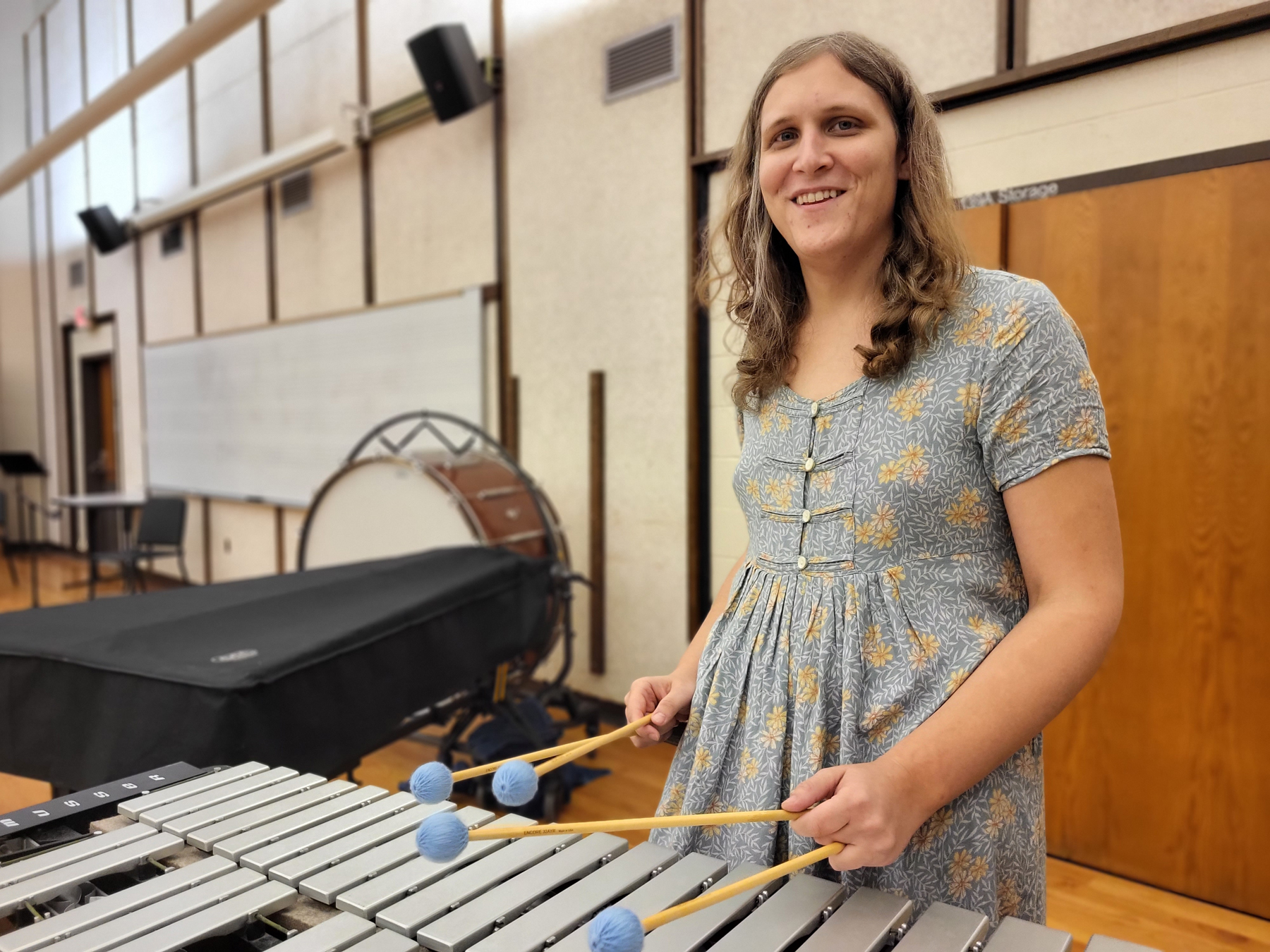 Joan Eason playing the vibraphone, holding mallets, smiling