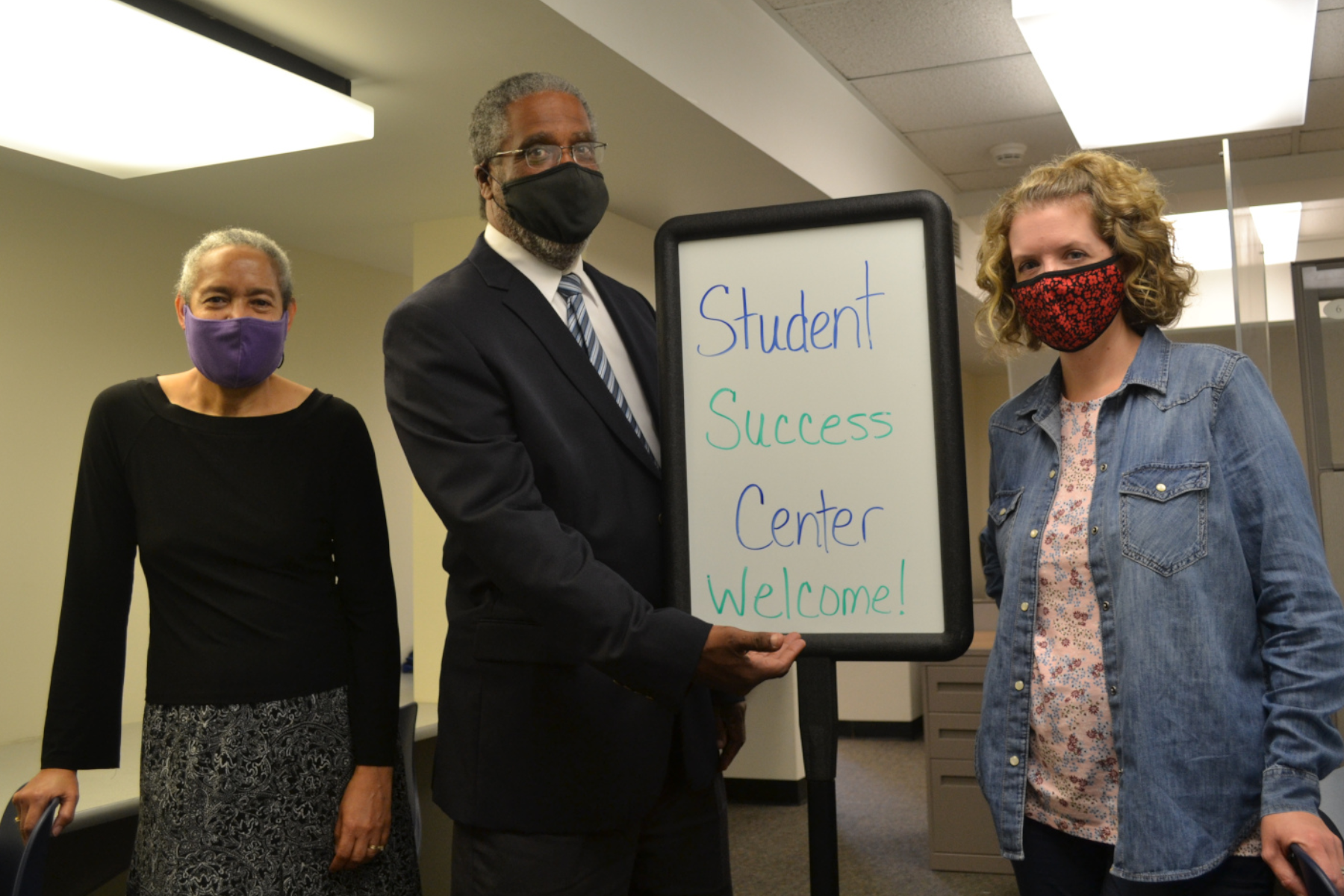 Student Success Coaches standing in Student Success Center with Student Success Center sign