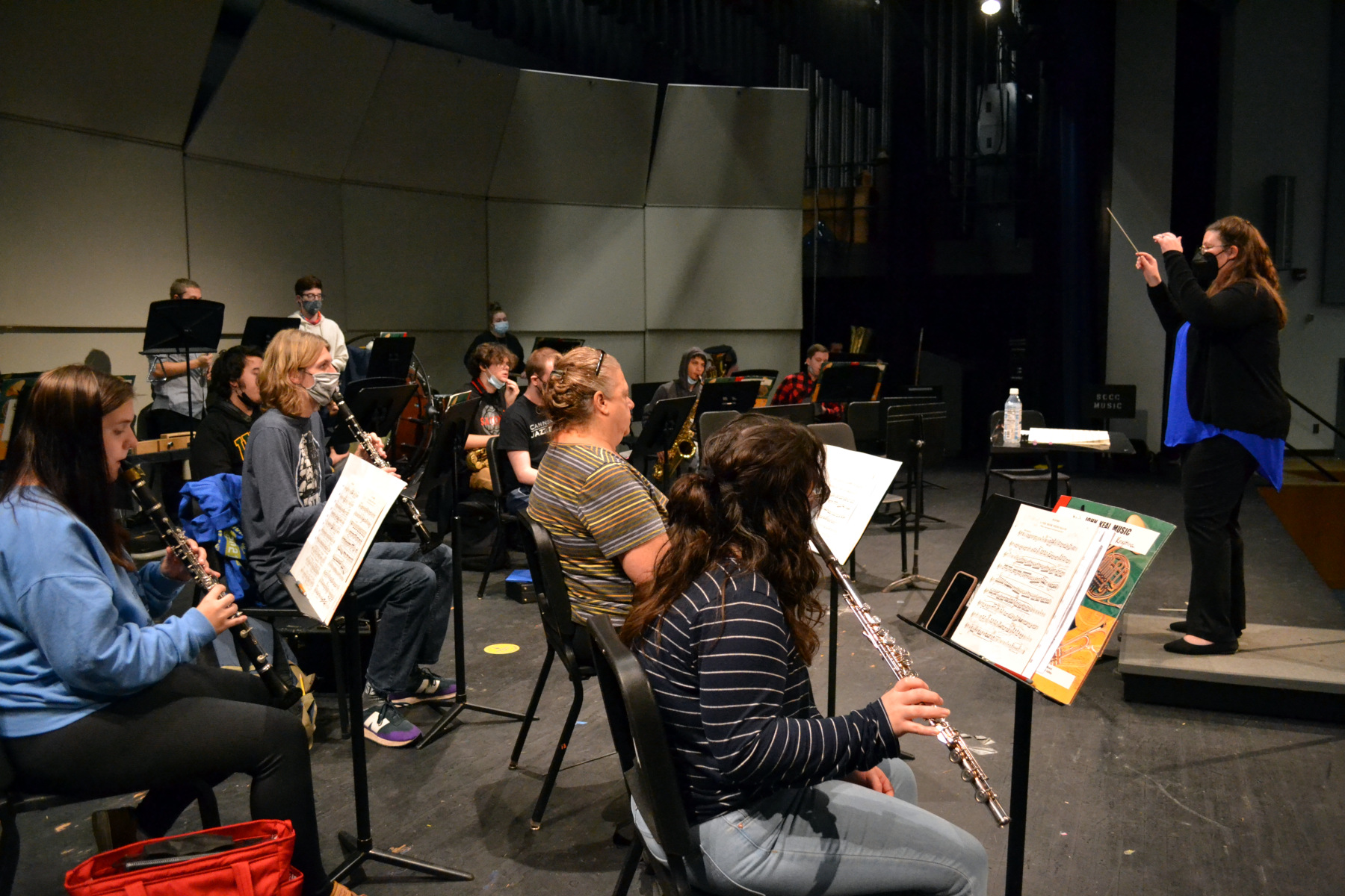 Students in wind ensemble rehearsing in auditorium